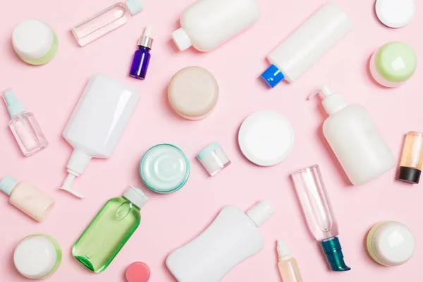 Plastik vücut bakım şişesi Grubu Düz tasarım için pembe arka plan boş alan kozmetik ürünleri ile kompozisyon yatıyordu. Beyaz Kozmetik kapları seti, fotokopi alanı ile üst görünüm.