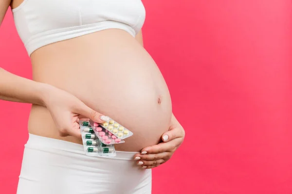コピースペースでカラフルな背景で母体サプリメントを保持妊娠中の女性のクローズアップ 水疱の中で丸薬 妊娠中の健康管理 — ストック写真
