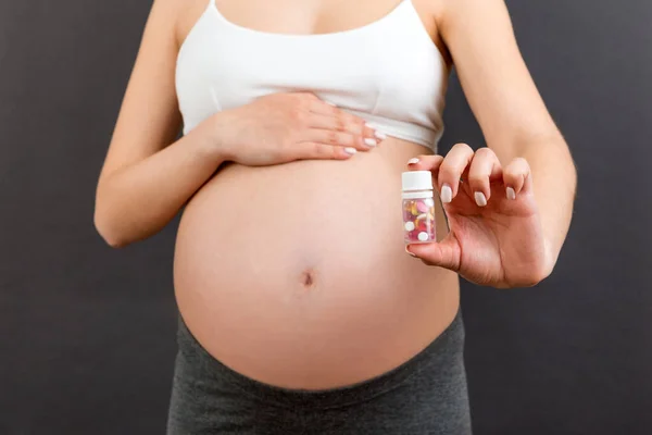 Primer Plano Mujer Embarazada Sosteniendo Una Botella Pastillas Contra Vientre — Foto de Stock