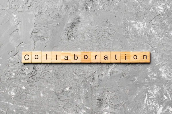 木のブロックに書かれたコラボレーションワード あなたのデザイン コンセプトのためのセメントテーブル上のコラボレーションテキスト — ストック写真