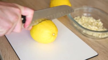 Mutfakta bir adam salamura için limon kesiyor..