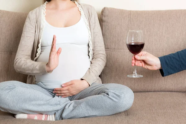 소파에 임산부를 가까이 와인을 마시기를 거부하고 몸짓을 멈춘다 임신중에는 마시지 — 스톡 사진