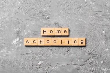 Ahşap blokta evde eğitim kelimesi yazıyor. Masada evde eğitim metni, konsept.