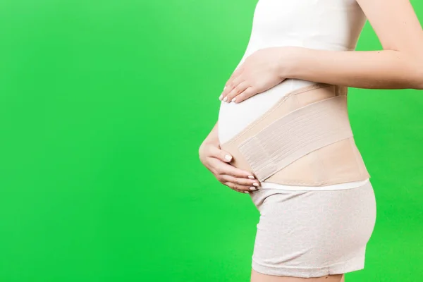Side View Pregnant Woman Wearing Elastic Maternity Band Green Background — Stock Photo, Image