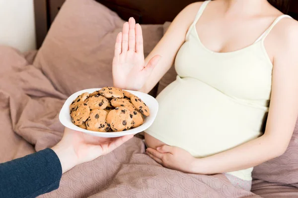 침대에 임신부를 가까이 보고도 과자를 먹으려 아무런 몸짓도 않는다 기간중의 — 스톡 사진