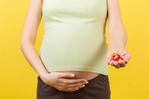 Close Van Zwangere Vrouw Met Een Stapel Pillen Kleurrijke Achtergrond — Stockfoto