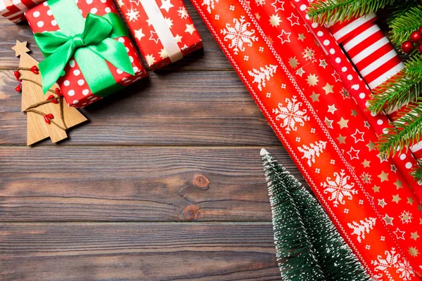モミの木で作られたクリスマスの背景のトップビュー 木製の背景に包装紙やその他の装飾を巻きました コピースペースと新年の休日の概念 — ストック写真