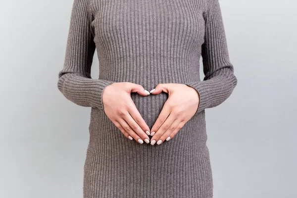 Close Jovem Grávida Vestido Cinza Fazendo Forma Coração Com Mãos — Fotografia de Stock