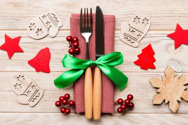 Ahşap arka planda çatal ve bıçak manzarası. Farklı Noel süslemeleri ve oyuncakları. Yeni yıl yemeği konseptini kapat..