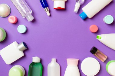 Plastik vücut bakım şişesi çerçevesi düz kompozisyonda renkli arka plan boşluğunda sizin tasarımınız için kozmetik ürünler sergileniyordu. Beyaz Kozmetik kapları kümesi, kopya alanı ile üst görünüm.