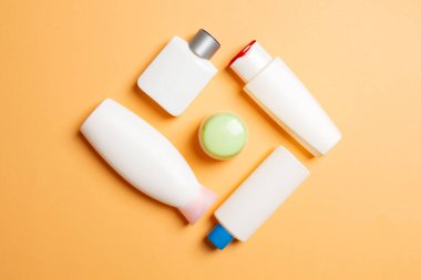 Renkli arkaplanda izole edilmiş Beyaz Kozmetik konteynırları seti, fotokopi alanı ile üst görünüm. Senin için bir grup plastik kaplar ve boş bir yer tasarladın..