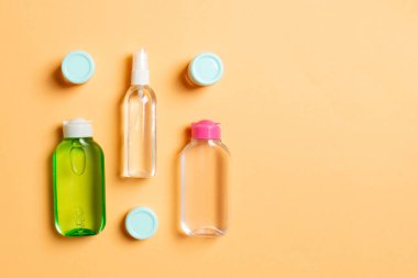 Kozmetik SPA marka modeli, fotokopi alanı olan üst görünüm. Renkli arka planda duran krema tüpleri ve kavanozları..