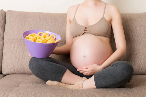 Primer Plano Mujer Embarazada Sentada Sofá Está Comiendo Patatas Fritas —  Fotos de Stock
