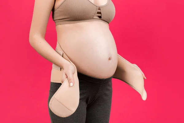 Close Pregnant Woman Putting Bandage Pink Background Copy Space Orthopedic — Stock Photo, Image