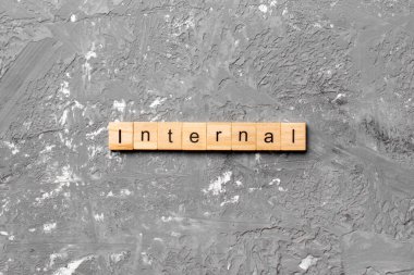 Tahta bloğa yazılmış interternal kelime. Çimento sehpası üzerindeki InterTERNAL metin desing, konsept.