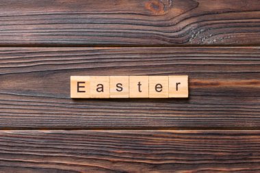 Tahta blokta yazan Paskalya kelimesi. Paskalya metni çimento masasında desing, konsept için.