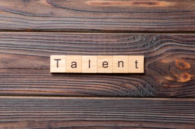 Tahta blokta yazılmış yetenekli bir kelime. Deksing, konsept için çimento masadaki yetenek metni.