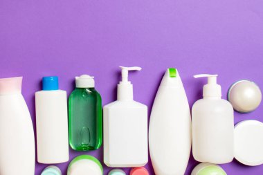 Plastik gövde bakımı şişesi düz kompozisyonu ve renkli arka plan boşluğuna kozmetik ürünler dizayn edilmişti. Beyaz Kozmetik kapları kümesi, kopya alanı ile üst görünüm.