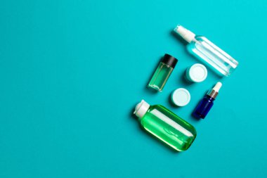 Kozmetik SPA marka modeli, fotokopi alanı olan üst görünüm. Renkli arka planda duran krema tüpleri ve kavanozları..