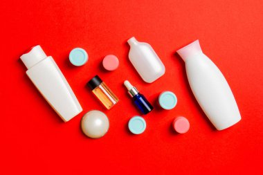 Kozmetik SPA marka modeli, fotokopi alanı olan üst görünüm. Renkli arka planda duran krema tüpleri ve kavanozları..