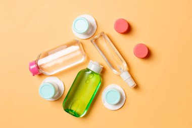 Renkli arka planda kozmetik ürünleri için küçük gezici şişelerin ve kavanozların üst görünümü. Tasarımınız için kopya alanı olan yüz bakımı konsepti.