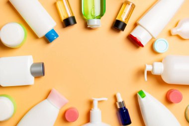 Plastik vücut bakım şişesi çerçevesi düz kompozisyonda renkli arka plan boşluğunda sizin tasarımınız için kozmetik ürünler sergileniyordu. Beyaz Kozmetik kapları kümesi, kopya alanı ile üst görünüm.