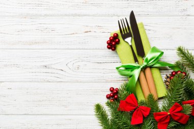 Ahşap arka planda noel süslerinin en üst görüntüsü. Peçetedeki çatal ve bıçak kurdeleyle bağlanmış ve senin tasarımın için boş bir alan. Yeni yıl şablonu kavramı.