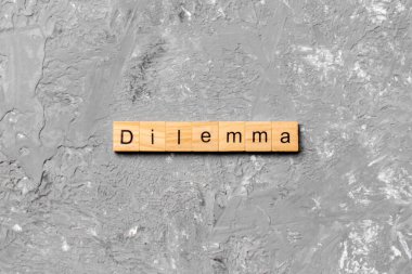 Tahta blokta yazan ikilem kelimesi. Desing, konsept için çimento masanın üzerindeki ikilem metni.