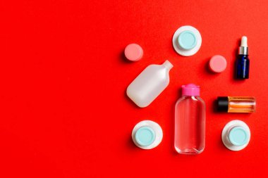 Renkli arka planda seyahat boyutunda kozmetik şişeler. Krema kavanozları düzdü. Vücut bakım stili kavramının en üst görünümü.