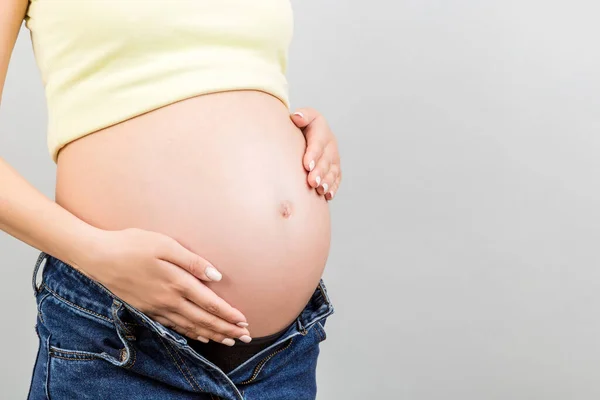 Primer Plano Mujer Embarazada Jeans Desabrochados Mostrando Vientre Desnudo Fondo —  Fotos de Stock