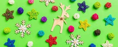 Yeşil arka planda yeni yıl süslemeleri. Kutlama yıldızları ve topları. Sancak Mutlu Noeller.