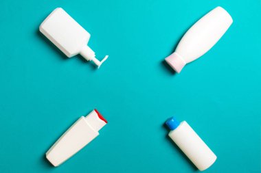 Renkli arkaplanda izole edilmiş Beyaz Kozmetik konteynırları seti, fotokopi alanı ile üst görünüm. Senin için bir grup plastik kaplar ve boş bir yer tasarladın..