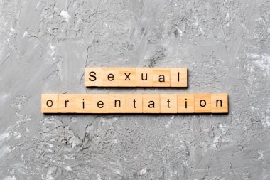 Tahta bloğa yazılmış cinsel yönelim kelimesi. Cinsel yönelim metniniz çimento üzerinde desing, kavram için.