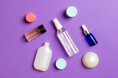 Kozmetik SPA marka modeli, fotokopi alanı olan üst görünüm. Renkli arka planda duran krema tüpleri ve kavanozları..