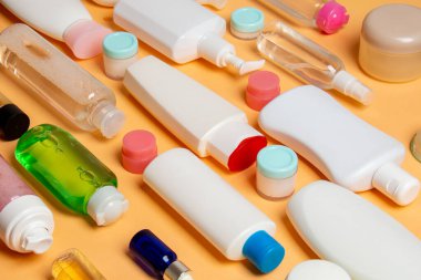 Plastik gövde bakımı şişesi düz kompozisyonu ve renkli arka plan boşluğuna kozmetik ürünler dizayn edilmişti. Beyaz Kozmetik kapları kümesi, kopya alanı ile üst görünüm.