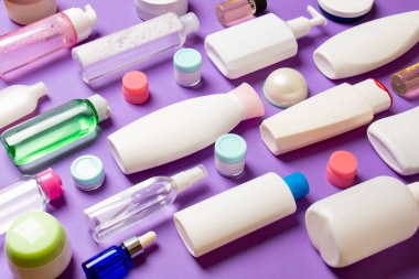 Plastik gövde bakımı şişesi düz kompozisyonu ve renkli arka plan boşluğuna kozmetik ürünler dizayn edilmişti. Beyaz Kozmetik kapları kümesi, kopya alanı ile üst görünüm.