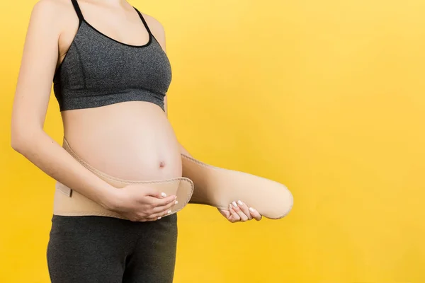 Primer Plano Mujer Embarazada Que Pone Cinturón Maternidad Vientre Fondo —  Fotos de Stock