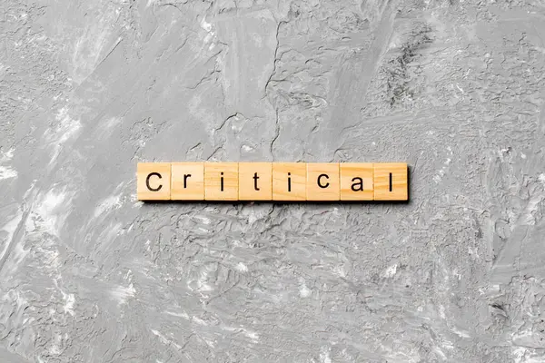 Tahta blokta kritik bir kelime yazıyor. masadaki kritik metin, konsept.