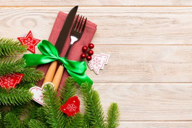 Yeni yıl ahşap arka planındaki şenlikli çatal bıçak takımının en üst görüntüsü. Tasarımınız için boş yeri olan Noel süslemeleri. Tatil yemeği konsepti.