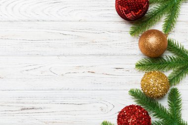 Noel kompozisyonu köknar ağacı, toplar ve ahşap arka planda farklı dekorasyonlardan oluşur. Tasarımınız için boş alanı olan Yeni Yıl Advent konseptinin üst görünümü.