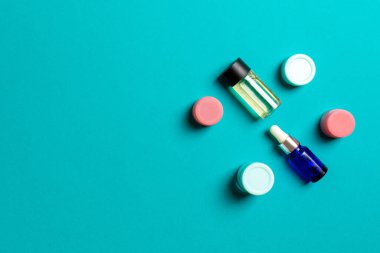 Kozmetik SPA marka modeli, fotokopi alanı olan üst görünüm. Renkli arka planda duran krema tüpleri ve kavanozları..