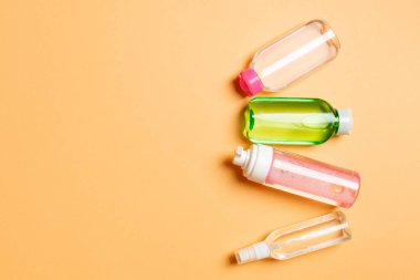 Kozmetik SPA marka modeli, fotokopi alanı olan üst görünüm. Renkli arka planda duran krema tüpleri ve kavanozları..