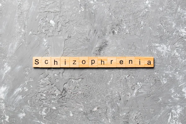 Tahta blokta yazan şizofreni kelimesi. Masada şizofreni metni, konsept.