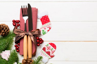 Yeni yıl ahşap arka planındaki şenlikli çatal bıçak takımının en üst görüntüsü. Tasarımınız için boş yeri olan Noel süslemeleri. Tatil yemeği konsepti.