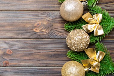Şenlik baloları, köknar ağacı ve ahşap arka planda Noel süslemeleri. Kopya alanı ile yeni yıl süsü konseptinin en üstü görünümü.