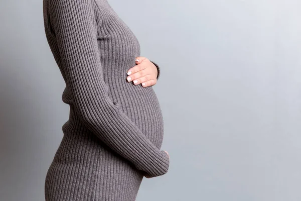 Großaufnahme Einer Schwangeren Frau Grauem Kleid Die Ihren Bauch Vor — Stockfoto