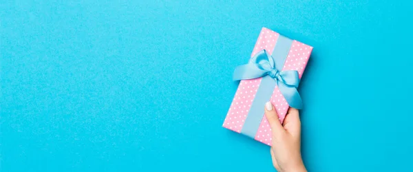 Vrouw Armen Houden Geschenkdoos Met Gekleurd Lint Blauwe Tafel Achtergrond — Stockfoto