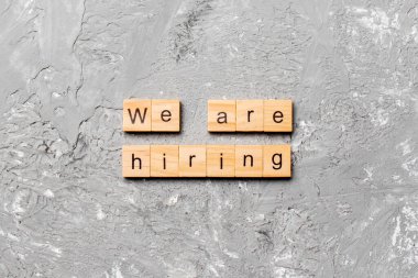 Tahta blokta yazılı bir kelime tutuyoruz. Çimento masasındaki metni senin için kiralıyoruz, Top view konsepti için..