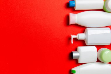 Plastik gövde bakımı şişesi düz kompozisyonu ve renkli arka plan boşluğuna kozmetik ürünler dizayn edilmişti. Beyaz Kozmetik kapları kümesi, kopya alanı ile üst görünüm.