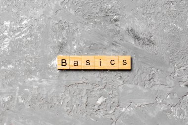 Tahta bloğa yazılmış BASICS kelimesi. Tablo üzerinde BASICS metin, konsept.